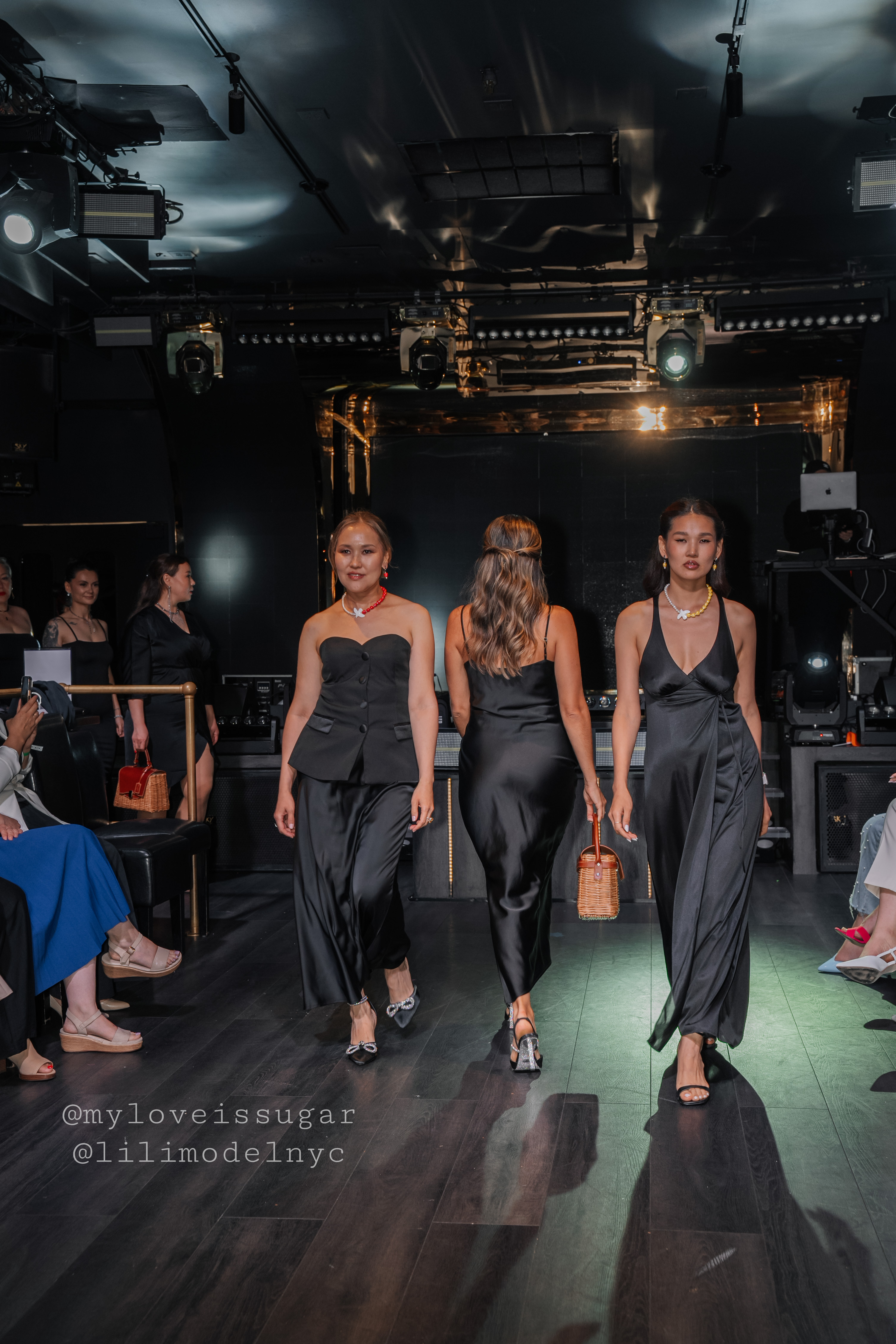 Women walking on runway in black dresses